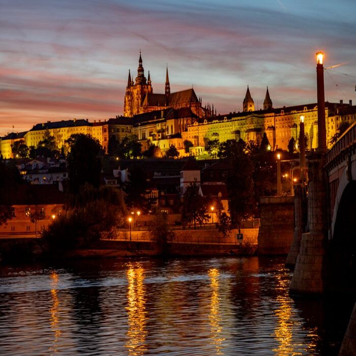 theatre-artist-template-repertoire-img-1 View of Prague Castle beautifully illuminated during twilight, reflected on the Vltava River.